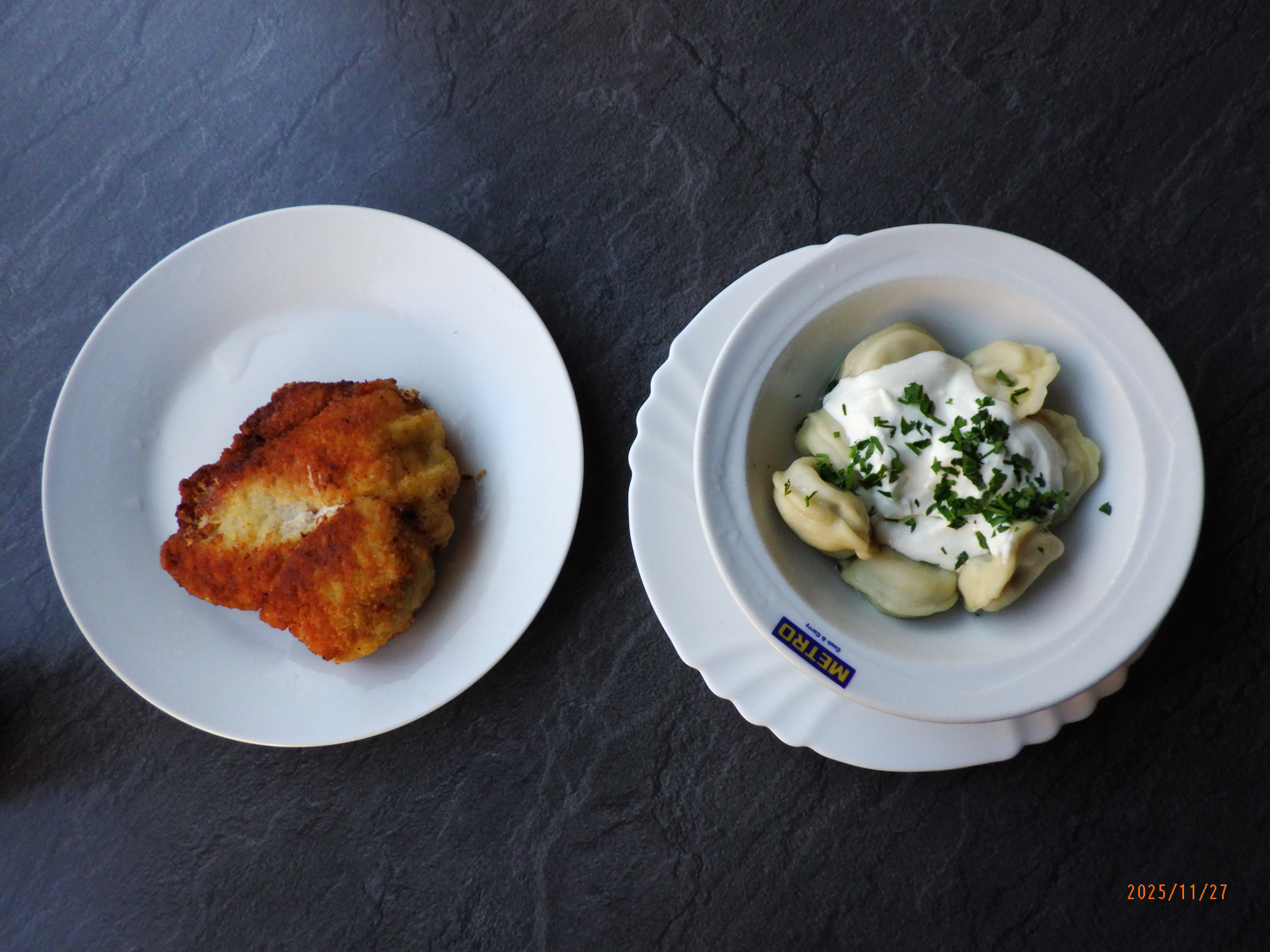 A fried kotlety cutlet on one plate and a bowl of pelmeni topped with sour cream